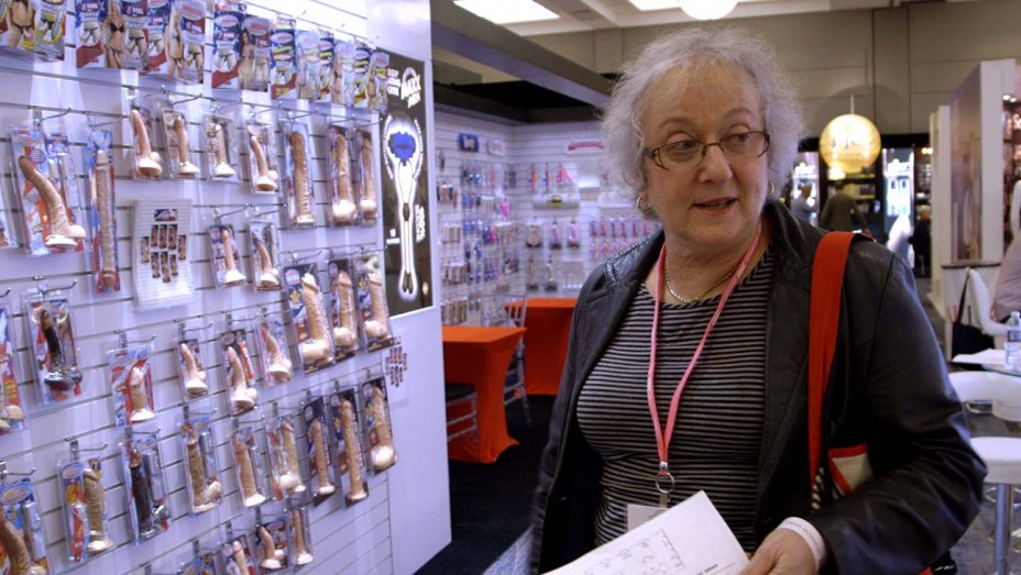 Karen in front of a wall covered in penis dildos