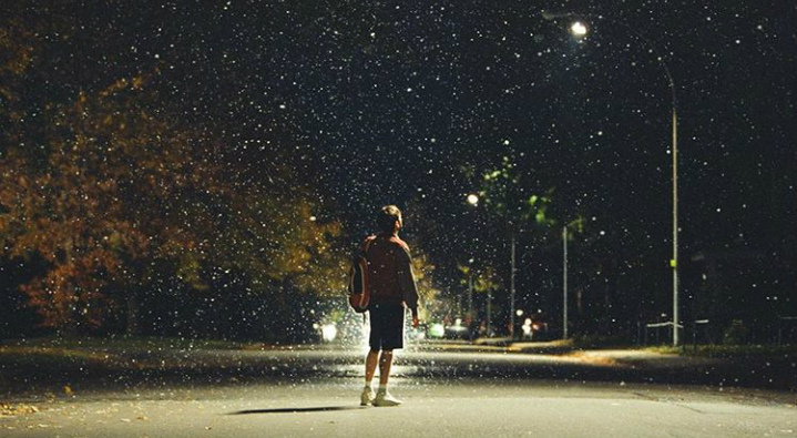 Maxime standing in the middle of the street with raindrops falling around him