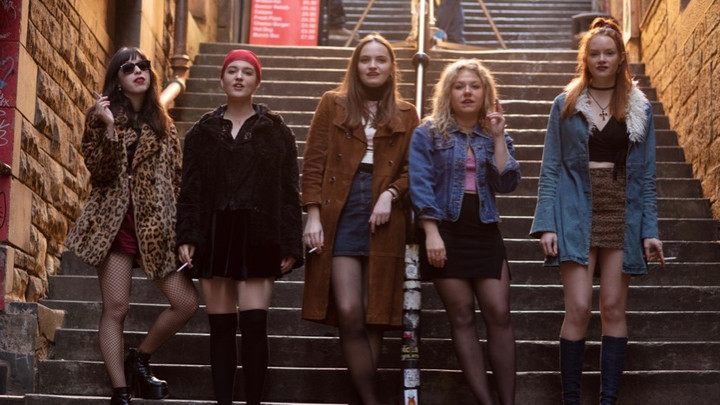 All five young women standing at the bottom of a tall set of stairs