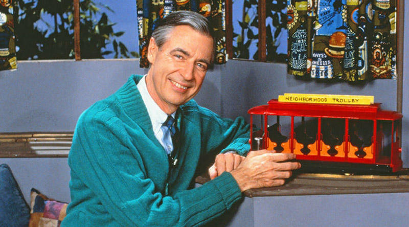 a shot of Mr Rogers with a toy train set on the set of his tv show
