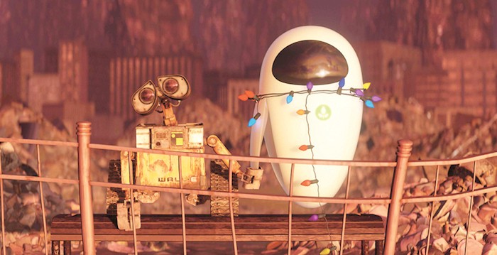 Screencapture from Wall-E. Two robots, one dirty and old and the other clean and new hold hands in a deserted wasteland.