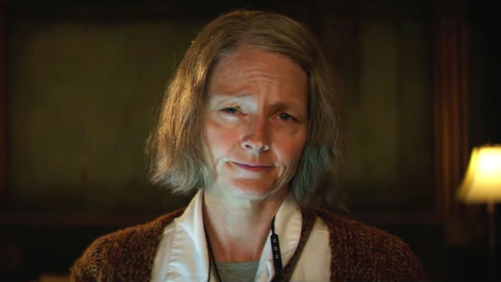 This image is a still from Hotel Artemis. The photo is a close up of Jodie Foster wearing make up to make her look much older. 
