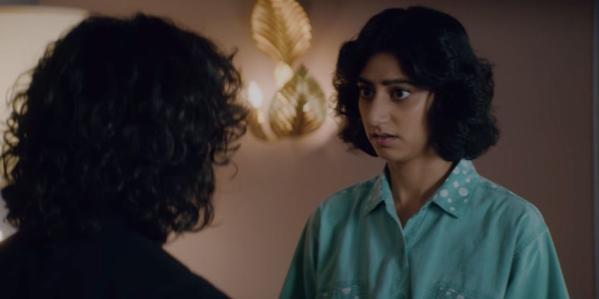 Arthie is standing having a conversation with Yolanda, out of her wrestling costume.