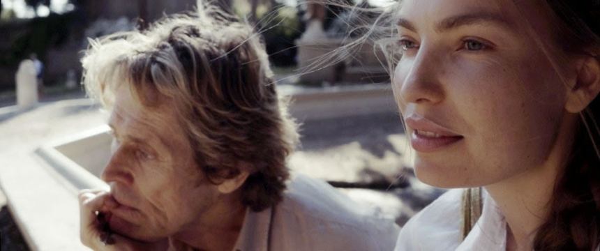 Close-up image of Willem Dafoe and Cristina Chiriac looking to the side.