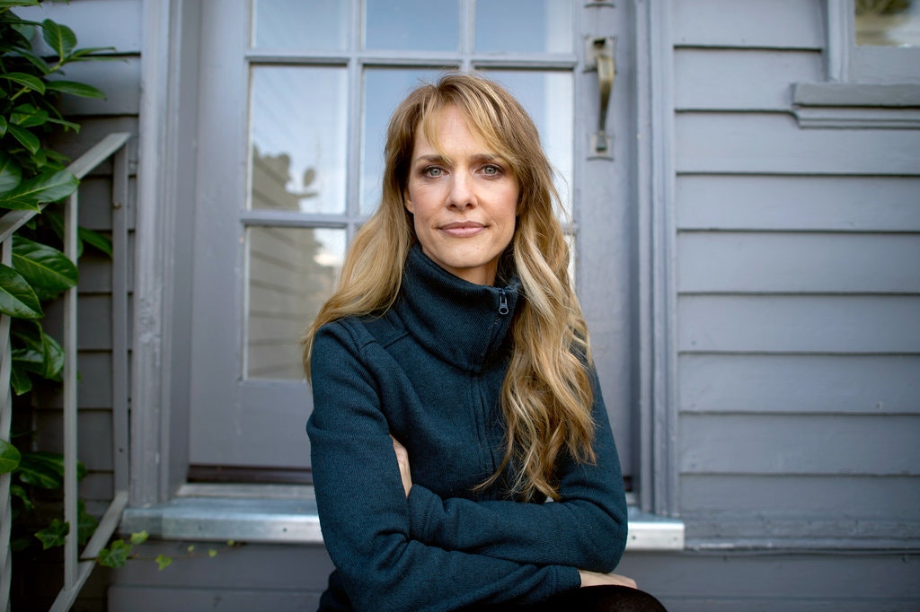 Image of director Lynn Shelton, who is sat on a porch outside of a house.