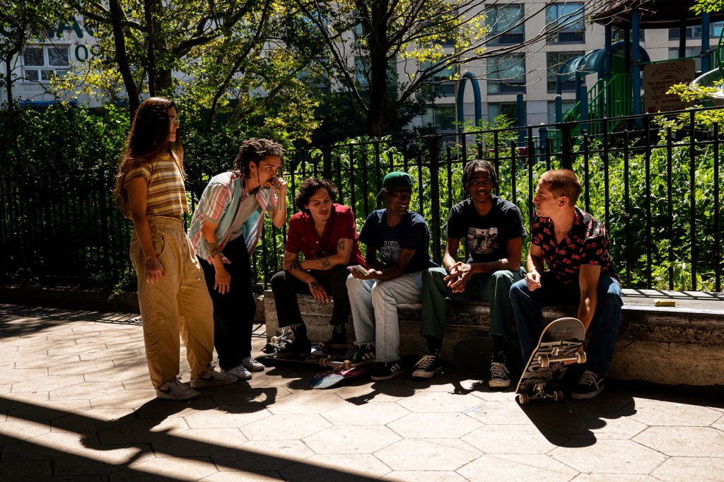 Camille is handing out with five male skaters at a park.