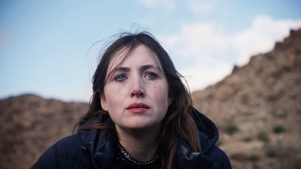 With a tear streaked face, Amy (Kate Sheil) sits up in the dessert.