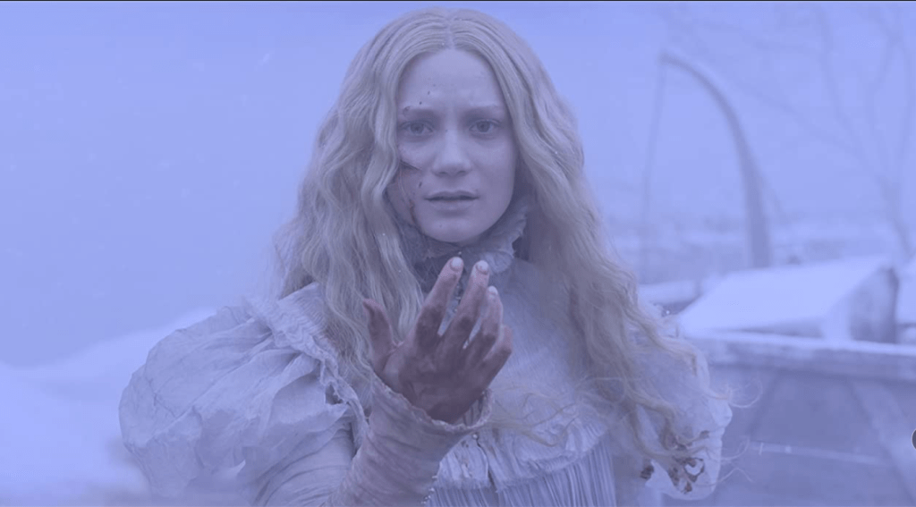 A pale woman in a white Victorian dress with long blonde hair stands outside in a blizzard, holding her blood spattered hand in front of her face with large cuts