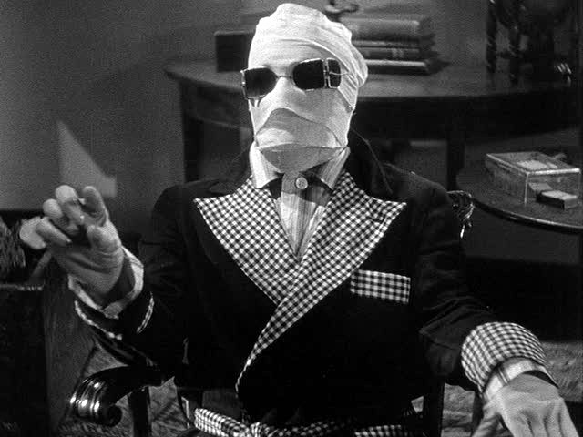 Claude Rains as The Invisible Man, wrapped in bandages and sitting down.