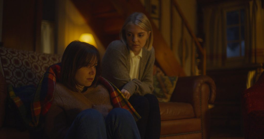 Emily comforts Rowan by the fireplace.