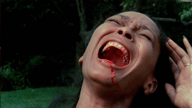 A Black woman screams with her head leaning back and blood in and around her mouth