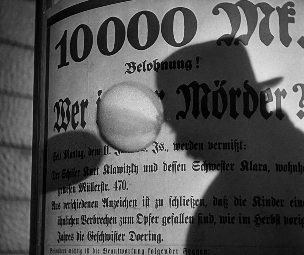 A silhouette of a man appears against a wall of German text.