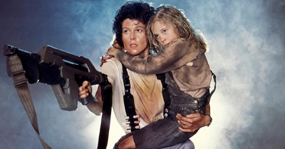 Sigourney Weaver holding a girl in movie still from Aliens.