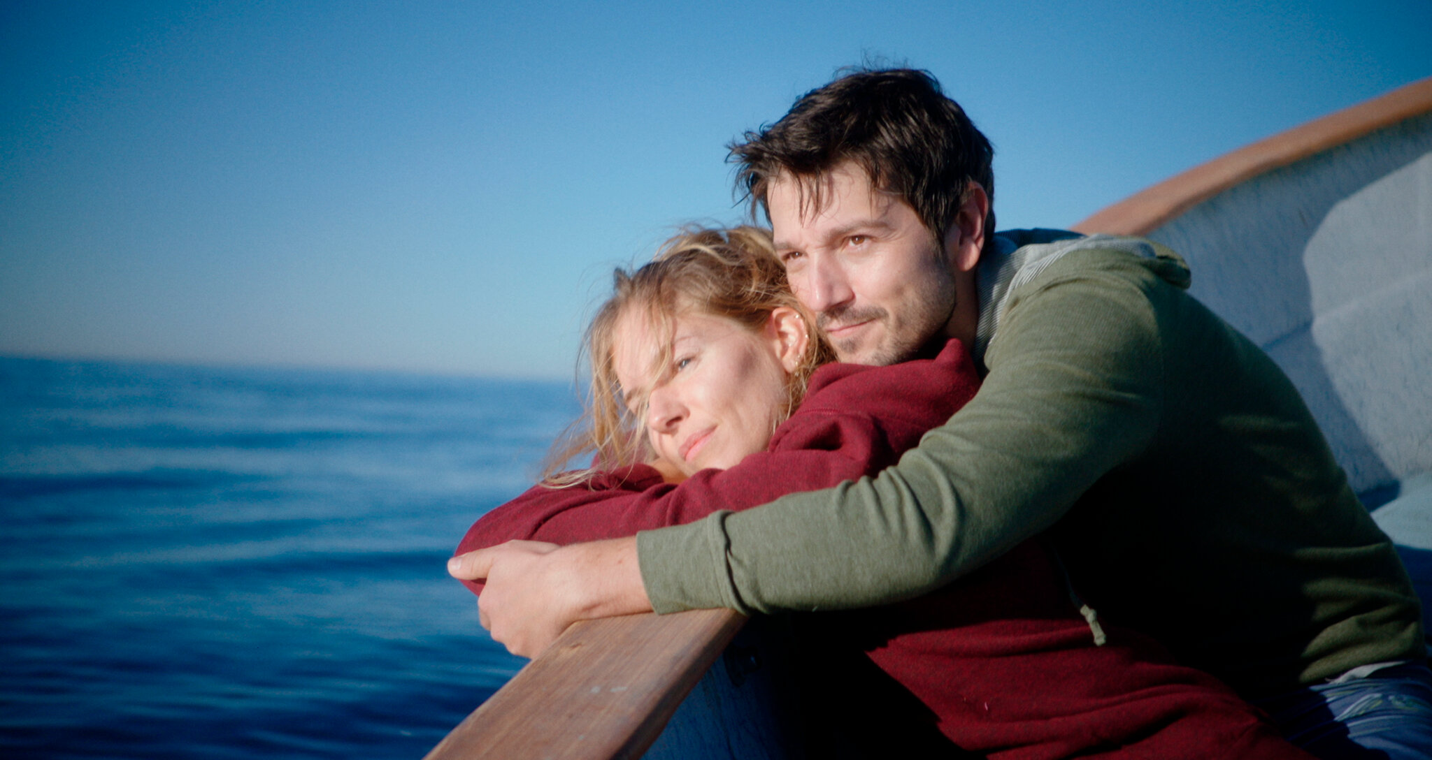Adrienne and Matteo are at their wedding, arms wrapped around each other looking very happy and in love.