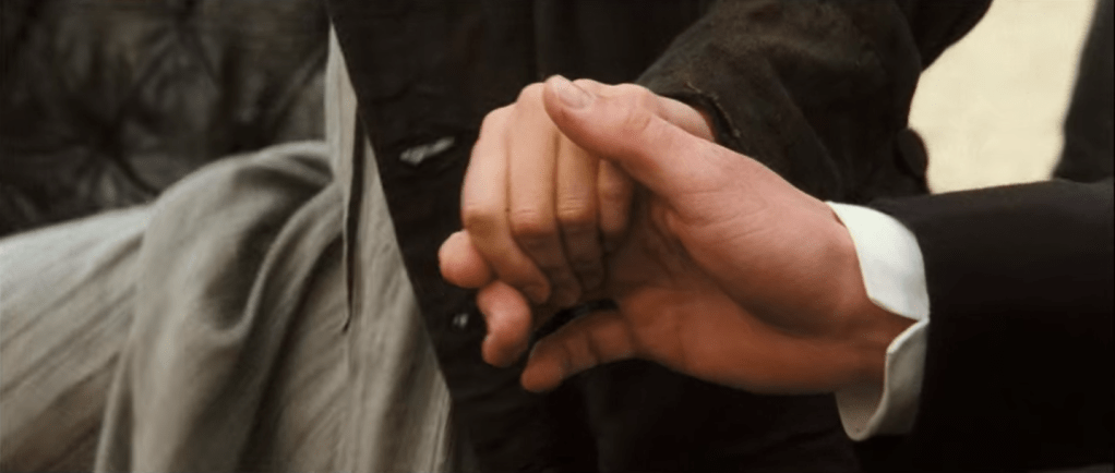 A close-up of Darcy and Elizabeth's hands as he helps her into a carriage.