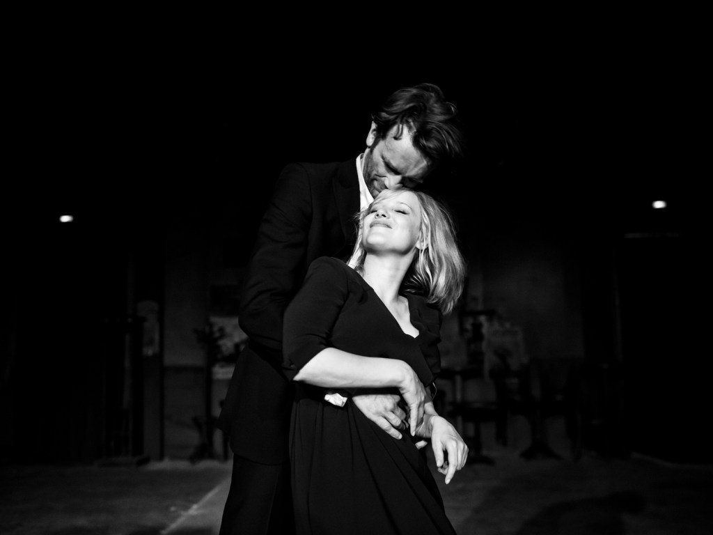 Image is from the film 'Cold War' (2018). Wiktor and Zula dancing in the jazz club, a spotlight is focused on them as they smile. The image is in black and white.