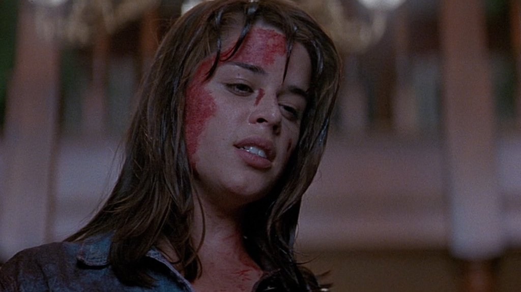 Neve Campbell as Sidney Prescott in Scream (1996.) She is looking down, the side of her head covered in blood.