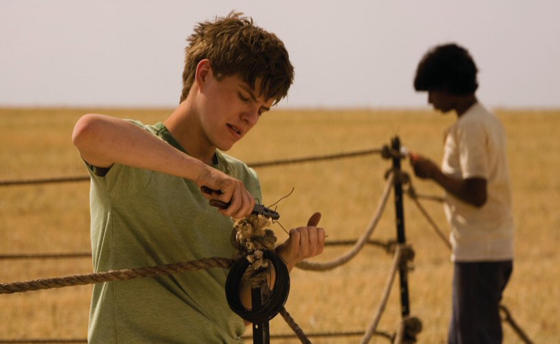 Image from the film September (2007). Ed (left) and Paddy (right) set up their boxing ring using rope, metal rods and wire in a corn field. 