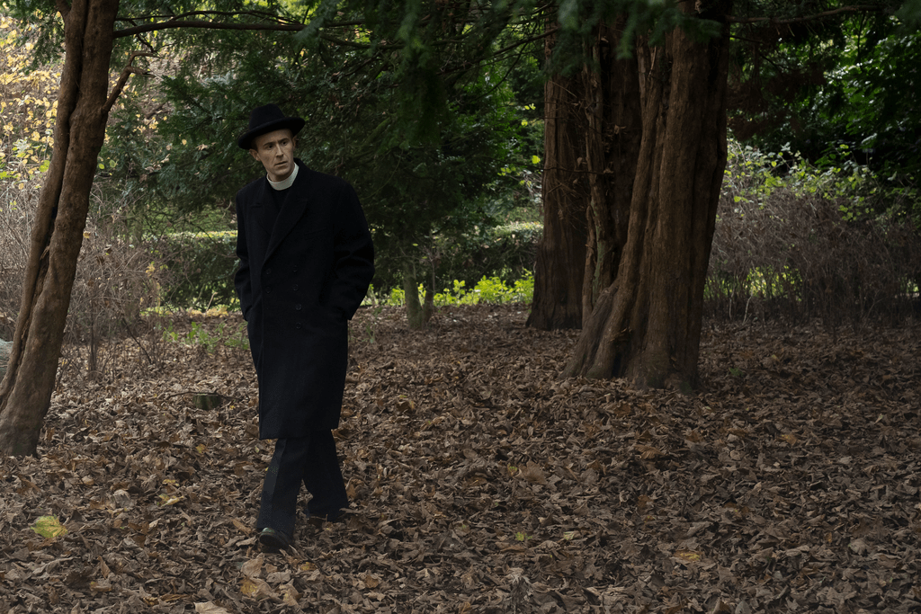 The vicar Linus (John Heffernan) looks pensive as he walks amongst fallen leaves