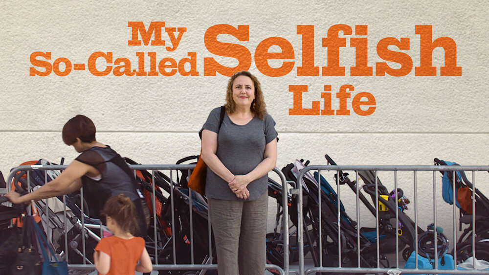Therese Shecter, a middle-aged white woman with short curly hair, stands in front of a white wall. The words 'My So-Called Selfish Life' are written in orange font. Behind her is a metal barricade with a row of strollers. To her left, a woman with short hair can be seen from behind as she pushes a stroller, next to a child in an orange shirt.
