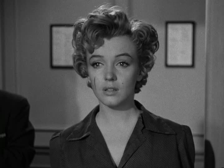 A still of Marilyn Monroe in 'Don't Bother to Knock'. She has a scratch on the left side of her face, and wears a button