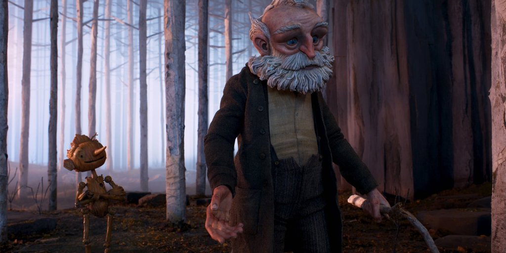 Still from "Guillermo del Toro's Pinocchio" showing Pinocchio walking behind his father Master Geppetto out in the middle of the forest. Pinocchio looks happy in his expression whilst his father, walking in front of him, looks more worried and concerned. 