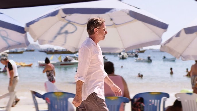 A still from 'Sundown' of Neil (Tim Roth) walking along the beach.
